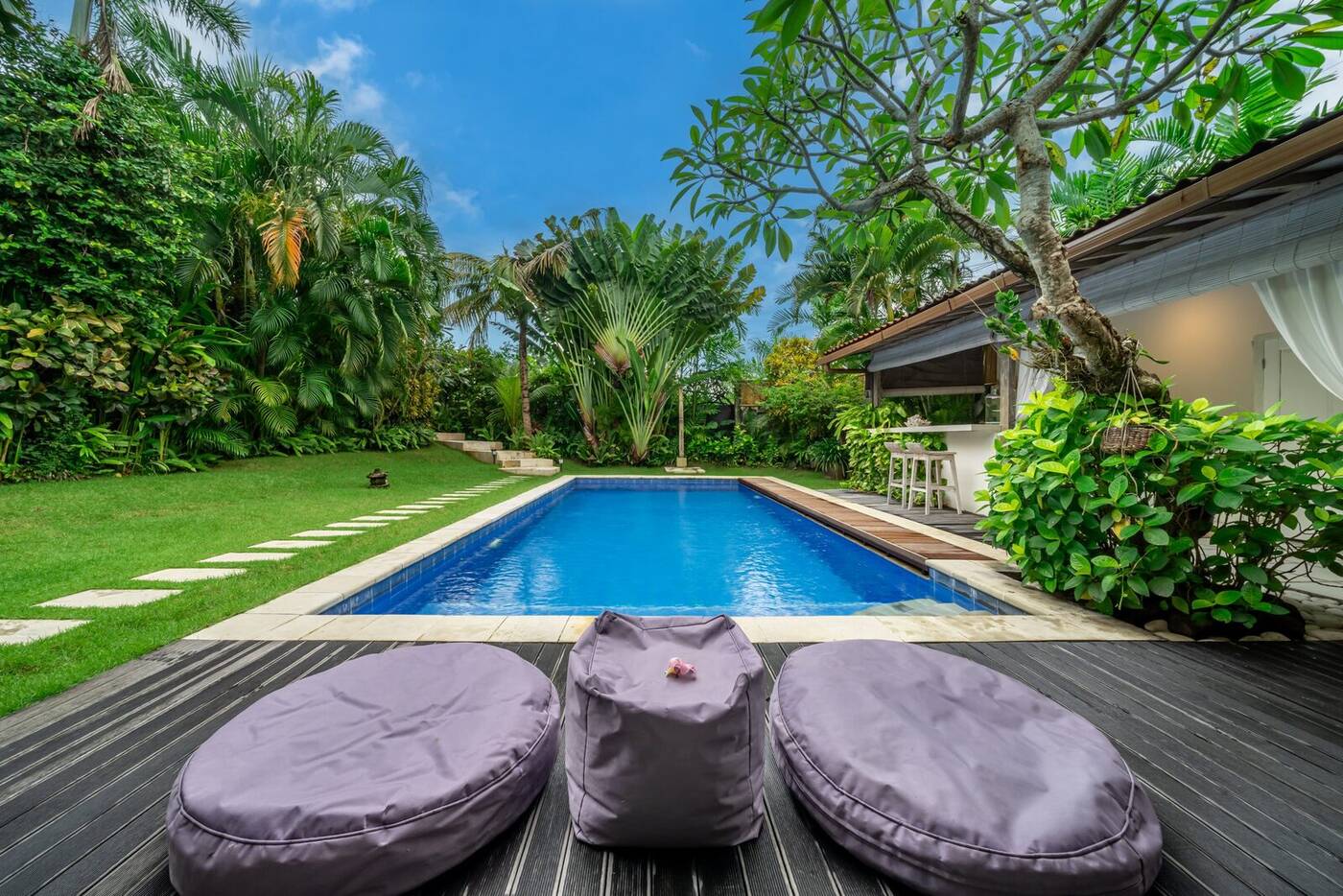 Pool deck with lounge cushions and tropical garden, Berawa, Bali