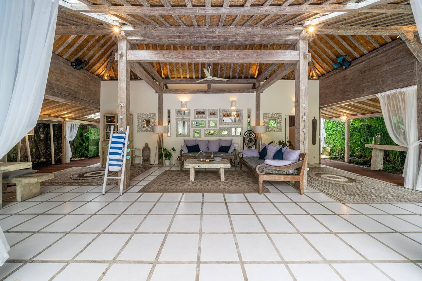 Open-air living area with sofas and carved mirrors, Balinese villa in Canggu, Bali